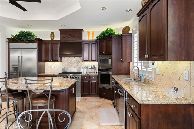 4009 Cerveza Cir, Corona, CA 92881 - kitchen featuring built in appliances, a sink, tasteful backsplash, a kitchen bar, and crown molding