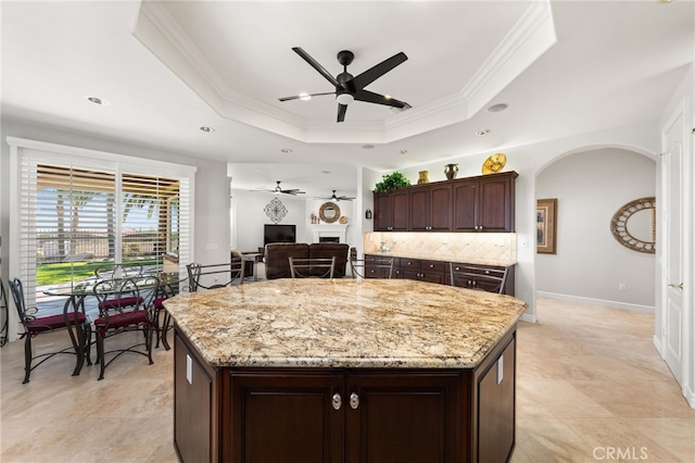 4009 Cerveza Cir, Corona, CA 92881 - kitchen featuring ceiling fan, a tray ceiling, decorative backsplash, crown molding, and a kitchen island