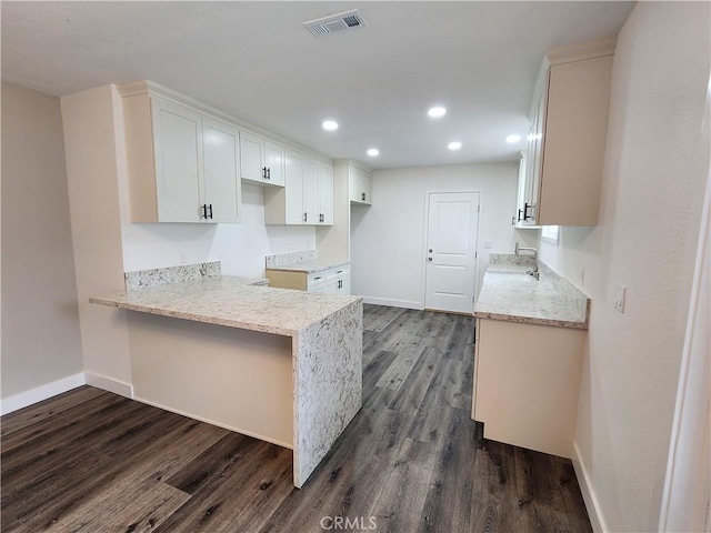 880 S State St, Hemet, CA 92543 - kitchen featuring dark wood finished floors, recessed lighting, a peninsula, light stone countertops, and white cabinets