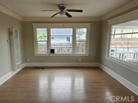4107 37th St, San Diego, CA 92105 - spare room with a heating unit, wood finished floors, plenty of natural light, baseboards, and crown molding