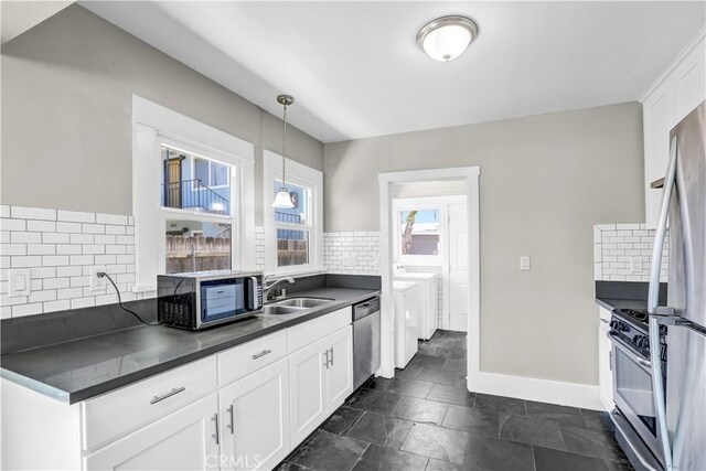 4107 37th St, San Diego, CA 92105 - kitchen with stainless steel appliances, washing machine and clothes dryer, dark countertops, and backsplash