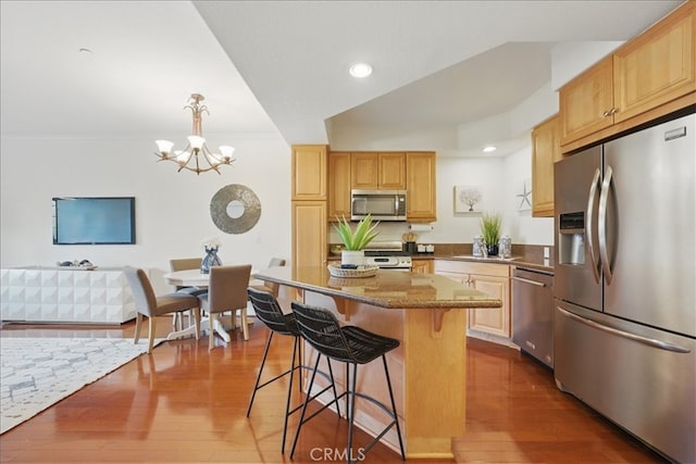 21345 Hawthorne Blvd Unit 126, Torrance, CA 90503 - kitchen featuring stainless steel appliances, a chandelier, a kitchen bar, dark wood-style flooring, and stone countertops