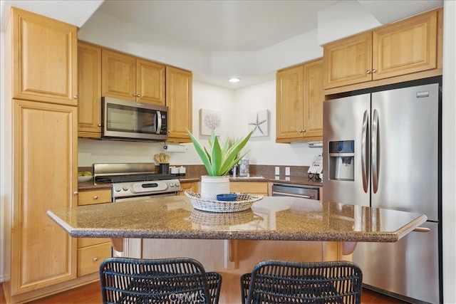 21345 Hawthorne Blvd Unit 126, Torrance, CA 90503 - kitchen featuring appliances with stainless steel finishes, recessed lighting, dark stone countertops, a kitchen breakfast bar, and a kitchen island