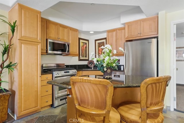 21345 Hawthorne Blvd Unit 126, Torrance, CA 90503 - kitchen with appliances with stainless steel finishes, a center island, dark stone counters, recessed lighting, and a breakfast bar