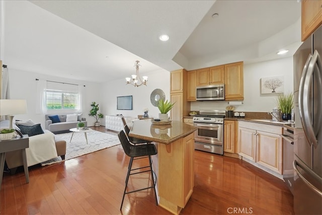 21345 Hawthorne Blvd Unit 126, Torrance, CA 90503 - kitchen with stainless steel appliances, a chandelier, a breakfast bar, open floor plan, and dark wood-style flooring