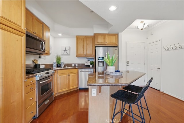 21345 Hawthorne Blvd Unit 126, Torrance, CA 90503 - kitchen featuring appliances with stainless steel finishes, a breakfast bar area, dark wood-style floors, a kitchen island, and recessed lighting