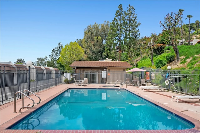 community pool featuring fence and a patio