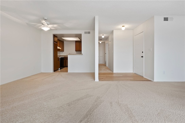 unfurnished living room featuring light colored carpet and a ceiling fan