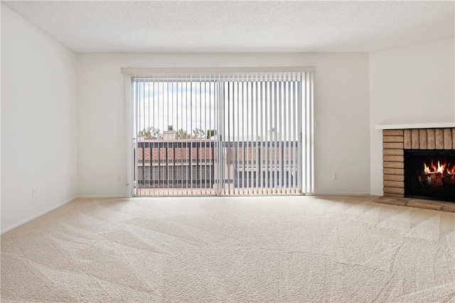 unfurnished living room featuring carpet floors, a fireplace, a textured ceiling, and baseboards