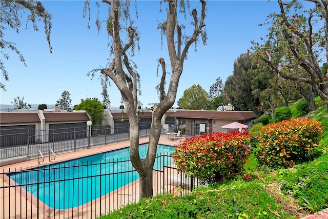 community pool with fence and a patio area