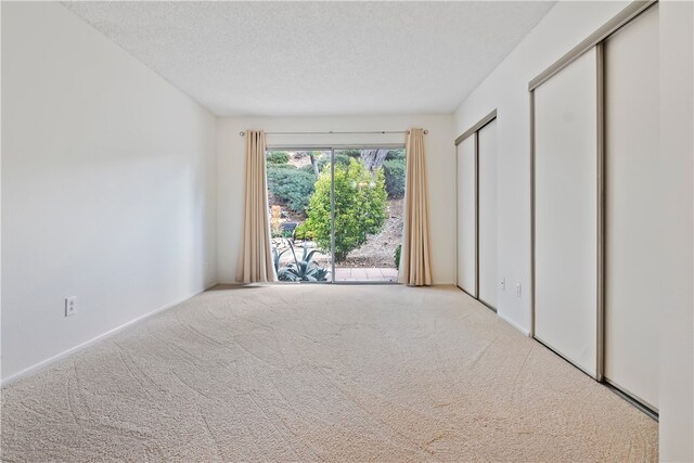 15555 Crestview Ln Unit 94, Granada Hills, CA 91344 - unfurnished bedroom featuring carpet flooring, a textured ceiling, multiple closets, and baseboards