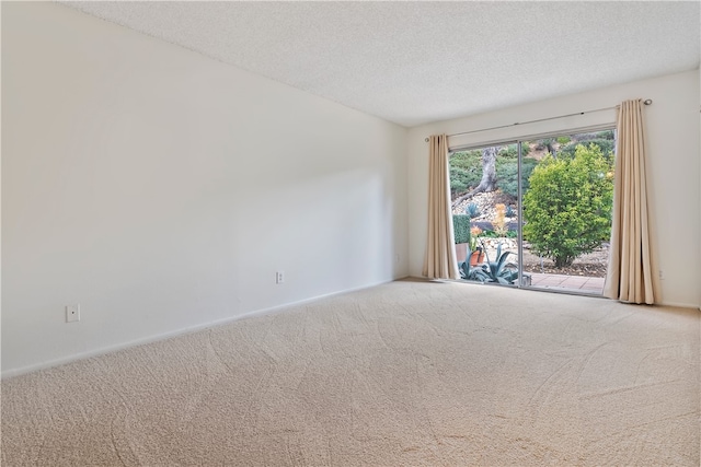 carpeted empty room with a textured ceiling and baseboards