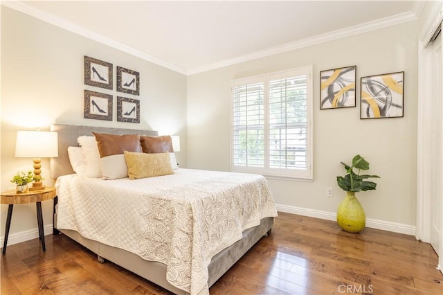 bedroom with crown molding, hardwood / wood-style floors, and baseboards