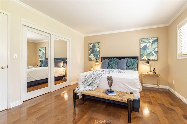 bedroom with ornamental molding, wood finished floors, and baseboards