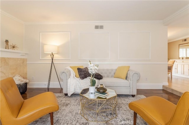 living room with wood finished floors, ornamental molding, and baseboards