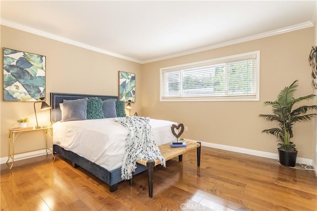 bedroom featuring baseboards, hardwood / wood-style floors, and crown molding