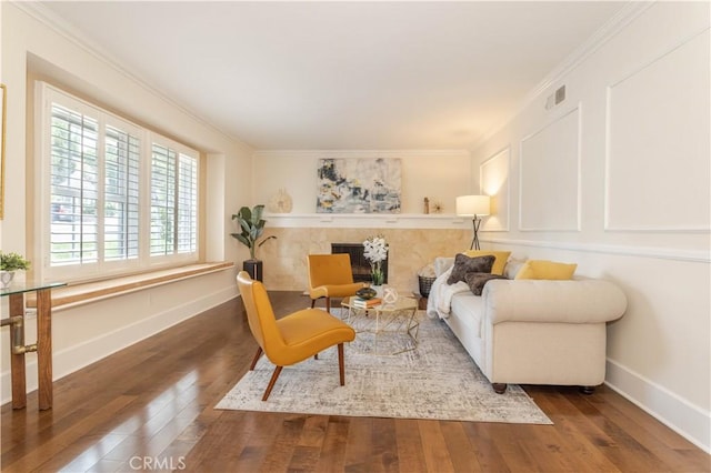 living area with hardwood / wood-style flooring, ornamental molding, and baseboards