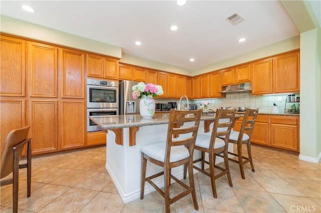 12538 Old Port Ct, Rancho Cucamonga, CA 91739 - kitchen with appliances with stainless steel finishes, light tile patterned floors, recessed lighting, tasteful backsplash, and brown cabinetry