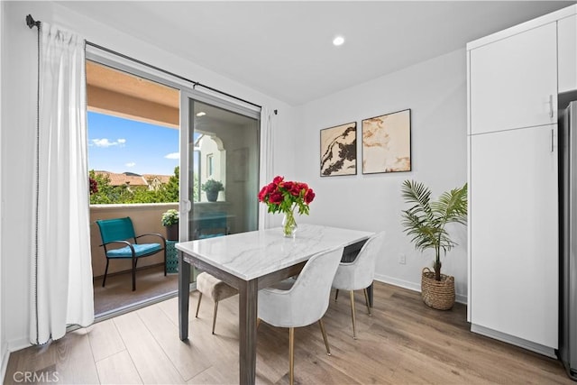 dining space with light wood-style flooring, recessed lighting, and baseboards