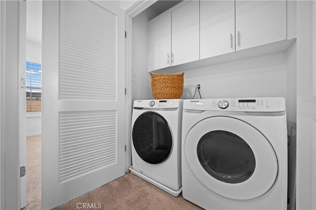 washroom with cabinet space, light carpet, and washing machine and clothes dryer
