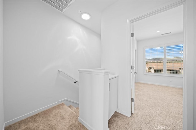 hall with light colored carpet, baseboards, an upstairs landing, and recessed lighting