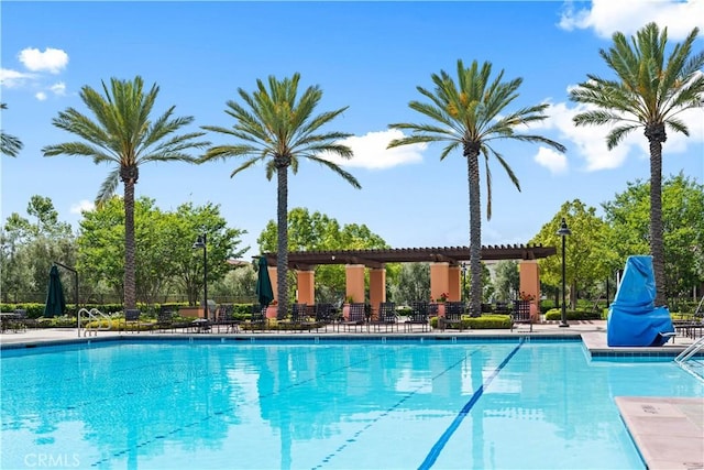 community pool featuring fence and a patio