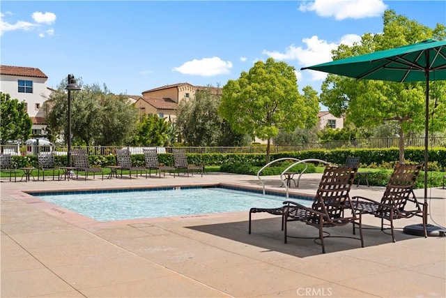 community pool featuring fence and a patio