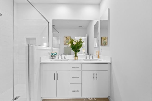bathroom with a stall shower and double vanity