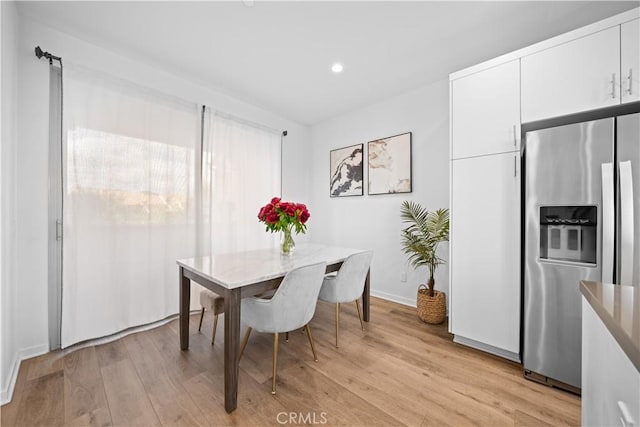 dining room with light wood-style flooring, baseboards, and recessed lighting