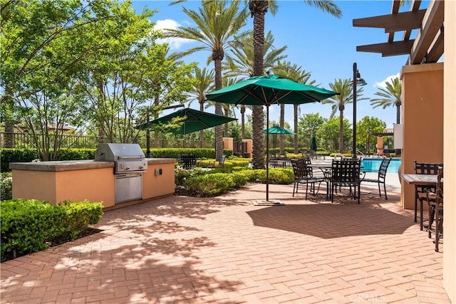 view of patio / terrace featuring an outdoor kitchen, area for grilling, fence, and outdoor dining area