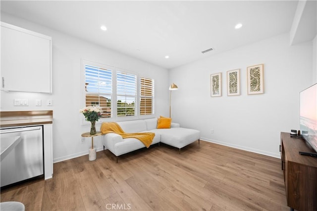 sitting room with wood finished floors, recessed lighting, and baseboards