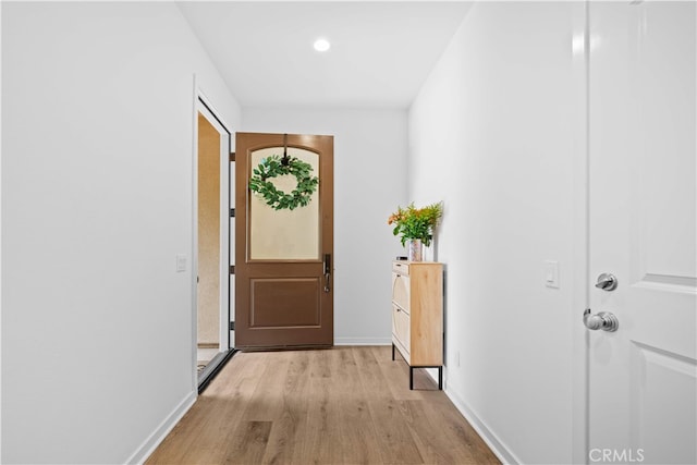 doorway featuring light wood-style floors and baseboards