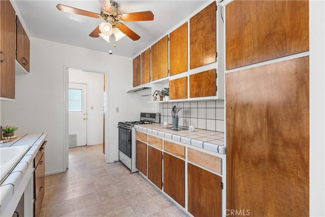 43348 E 6th St, Lancaster, CA 93535 - kitchen featuring range with gas cooktop, a ceiling fan, tasteful backsplash, brown cabinetry, and tile countertops