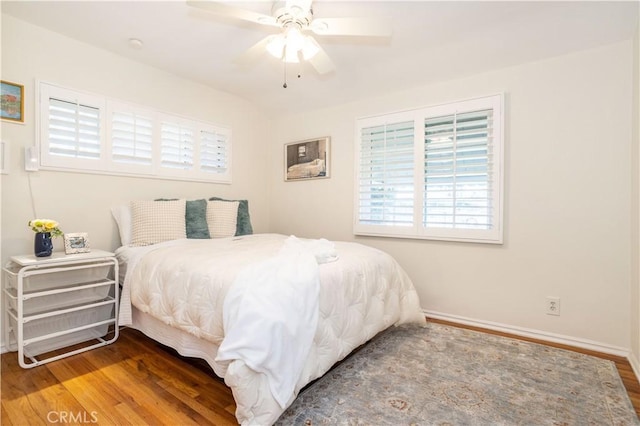 bedroom with wood finished floors, baseboards, and ceiling fan