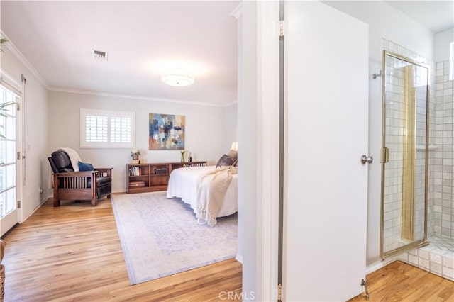 bedroom with light wood finished floors, ornamental molding, and baseboards