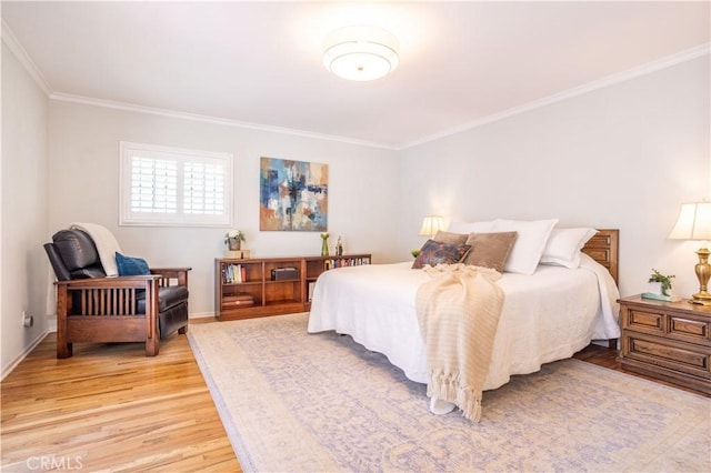 bedroom with crown molding, light wood-style flooring, and baseboards