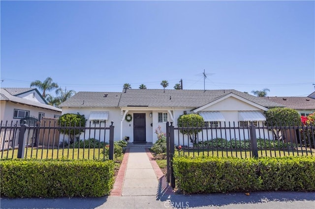 view of front of property featuring stucco siding and roof with shingles