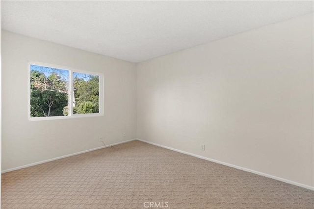 carpeted spare room with baseboards