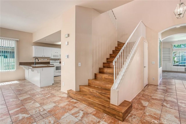 588 Twin Hills Dr, Banning, CA 92220 - stairway with arched walkways and stone tile floors
