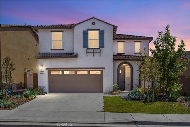 2335 Powell Dr, Rialto, CA 92377 - mediterranean / spanish house with driveway, a tiled roof, a garage, and stucco siding