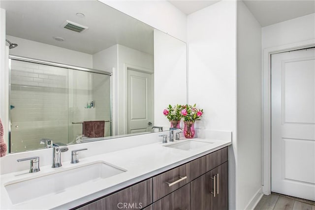 2335 Powell Dr, Rialto, CA 92377 - bathroom with a shower stall, wood finished floors, double vanity, and baseboards