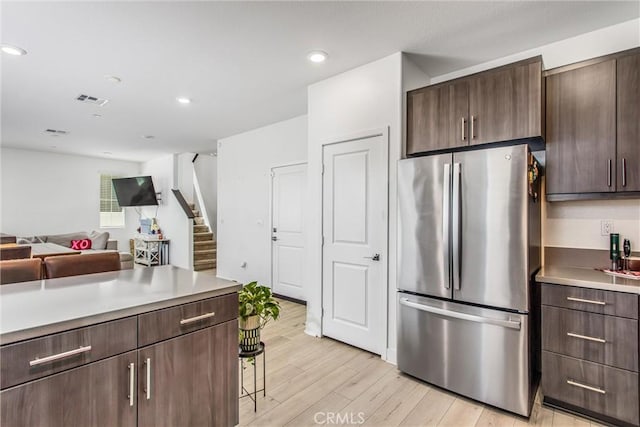 2335 Powell Dr, Rialto, CA 92377 - kitchen featuring freestanding refrigerator, light wood finished floors, dark brown cabinets, open floor plan, and recessed lighting