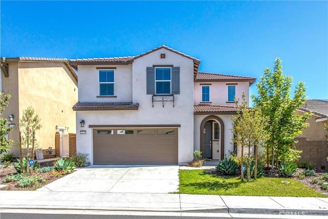 2335 Powell Dr, Rialto, CA 92377 - mediterranean / spanish home featuring an attached garage, driveway, a tile roof, and stucco siding