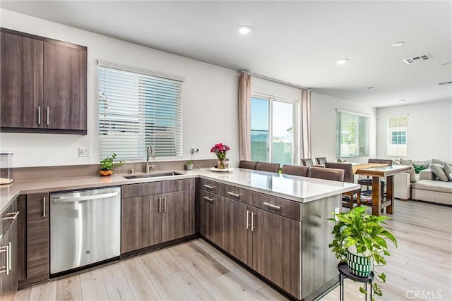 2335 Powell Dr, Rialto, CA 92377 - kitchen featuring stainless steel dishwasher, a sink, open floor plan, a peninsula, and light wood-style flooring