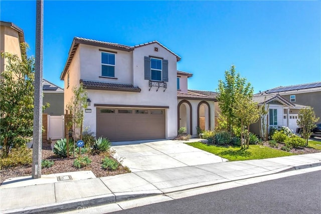 2335 Powell Dr, Rialto, CA 92377 - mediterranean / spanish-style house with a tiled roof, stucco siding, an attached garage, and concrete driveway
