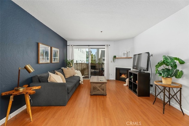 1100 Euclid Ave Unit 108, Long Beach, CA 90804 - living room with wood finished floors, a lit fireplace, a textured wall, and a textured ceiling