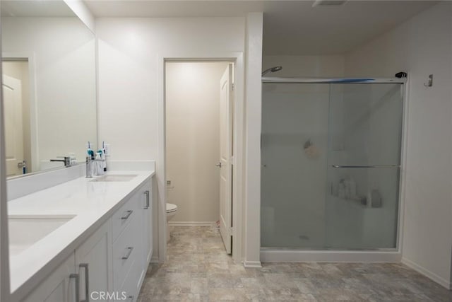 1810 Park Place Ln, Riverside, CA 92501 - bathroom with double vanity, a shower stall, toilet, and baseboards