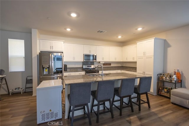 1810 Park Place Ln, Riverside, CA 92501 - kitchen featuring appliances with stainless steel finishes, white cabinets, a center island with sink, dark wood-style floors, and recessed lighting