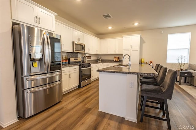 1810 Park Place Ln, Riverside, CA 92501 - kitchen featuring stainless steel appliances, a sink, white cabinets, dark wood finished floors, and recessed lighting