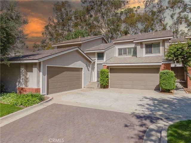 6523 E Camino Unit 2, Anaheim, CA 92807 - view of front of house featuring decorative driveway, stucco siding, and a shingled roof